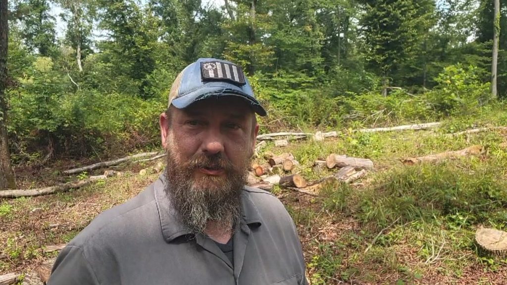 Brian at the future solar array site after clearing trees and brush